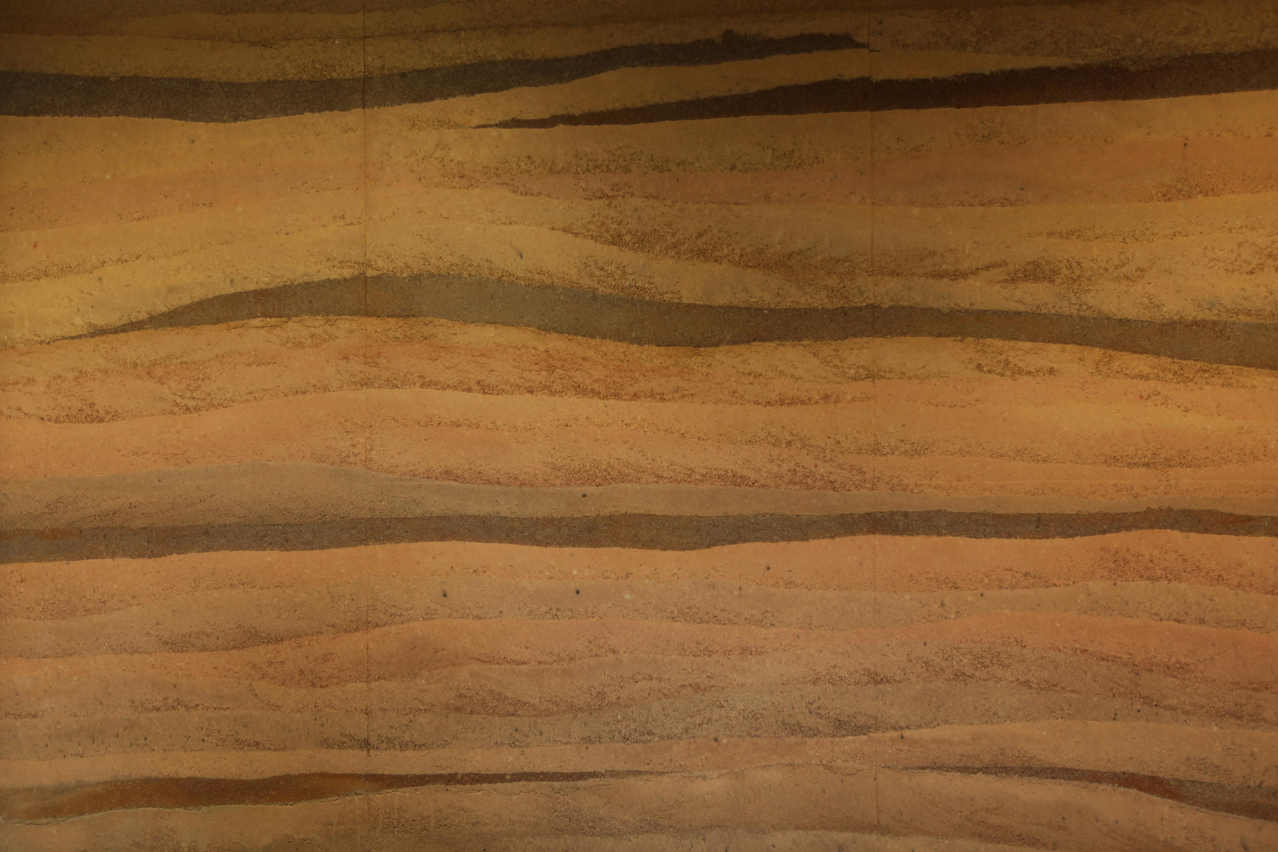 Mud Hut Rebirth, a close up view of the ferrimagnetic rammed earth wall