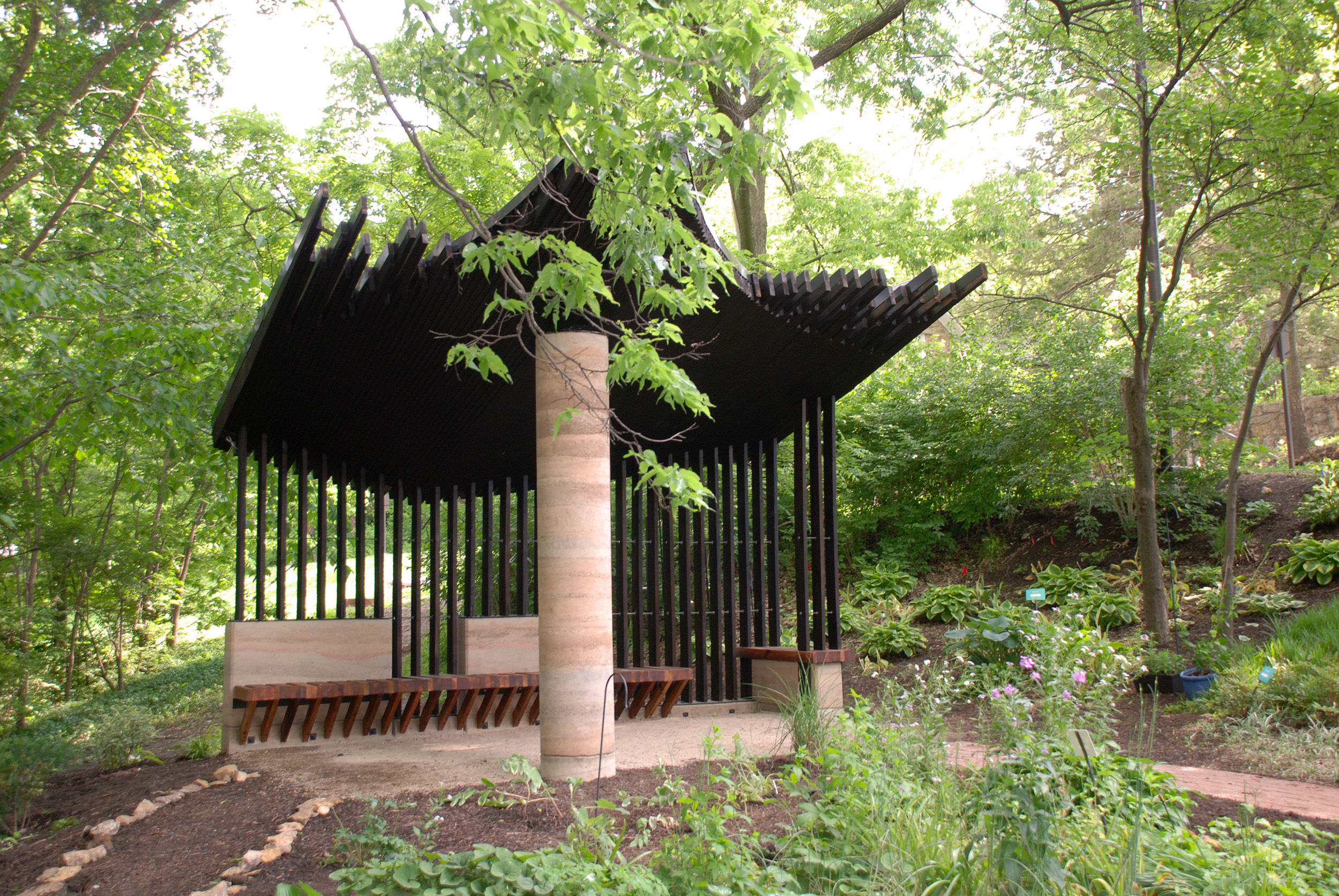 Sensory Pavilion, with a feathered canopy edge supported by a rammed earth column