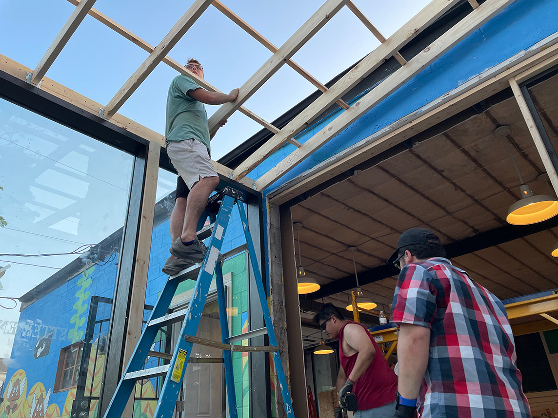 students building a greenhouse roof