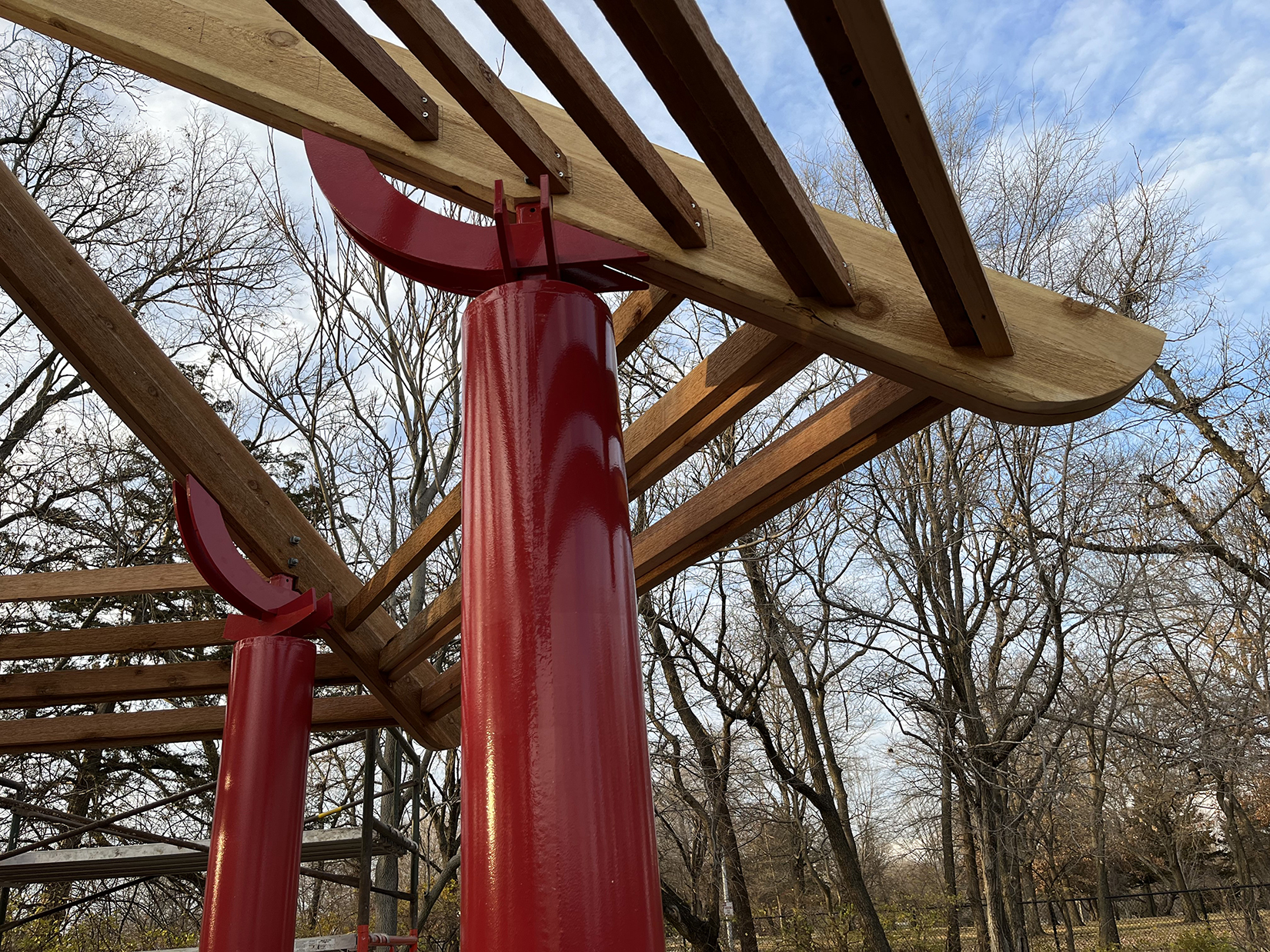 Red steel structure supports wooden frame