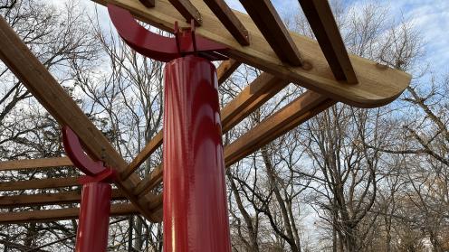 Red steel structure supports wooden frame